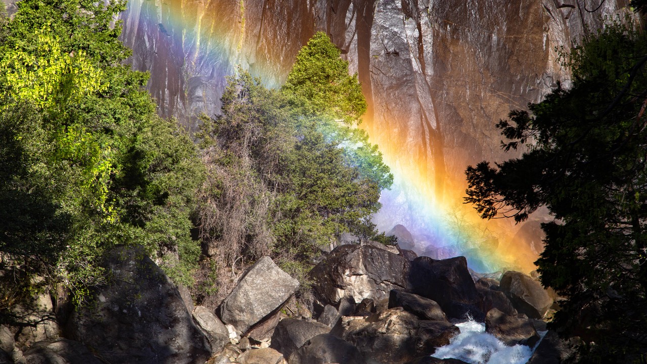 A rainbow appears in the mist of Lower Yosemite Falls. 