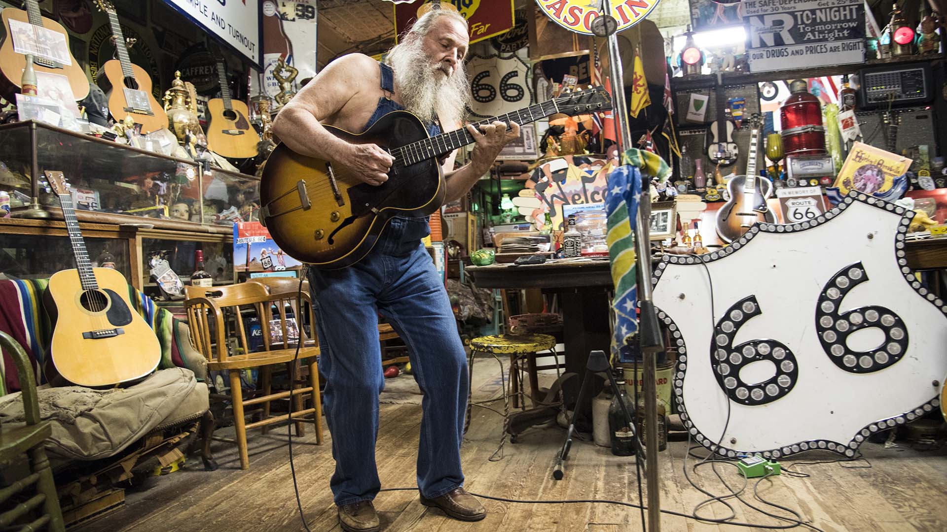 Harly Russell, le propriétaire unique en son genre de la boutique de curiosités de Sandhills à Erick, en Oklahoma, joue de la guitare pour les visiteurs.