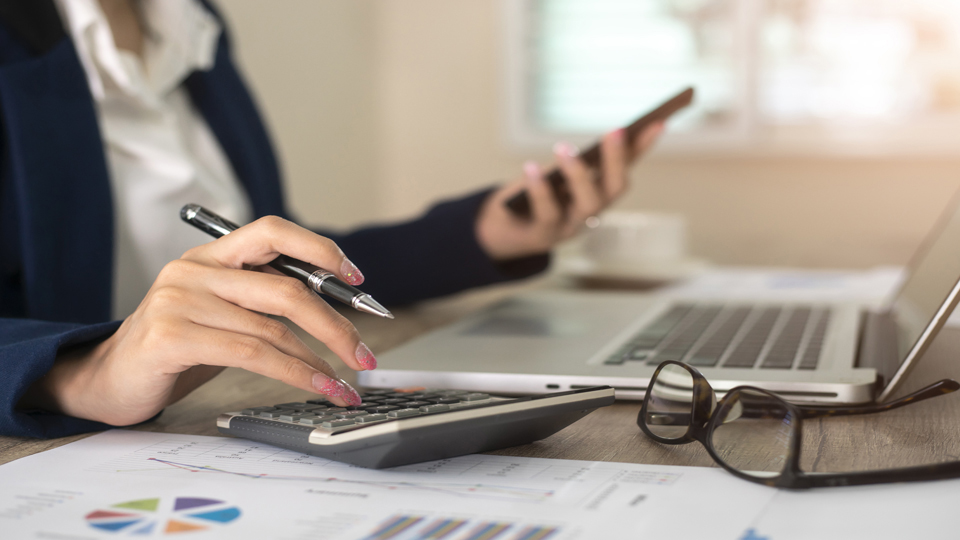 Close up of female accountant or banker making calculations. Savings, finances and economy concept
