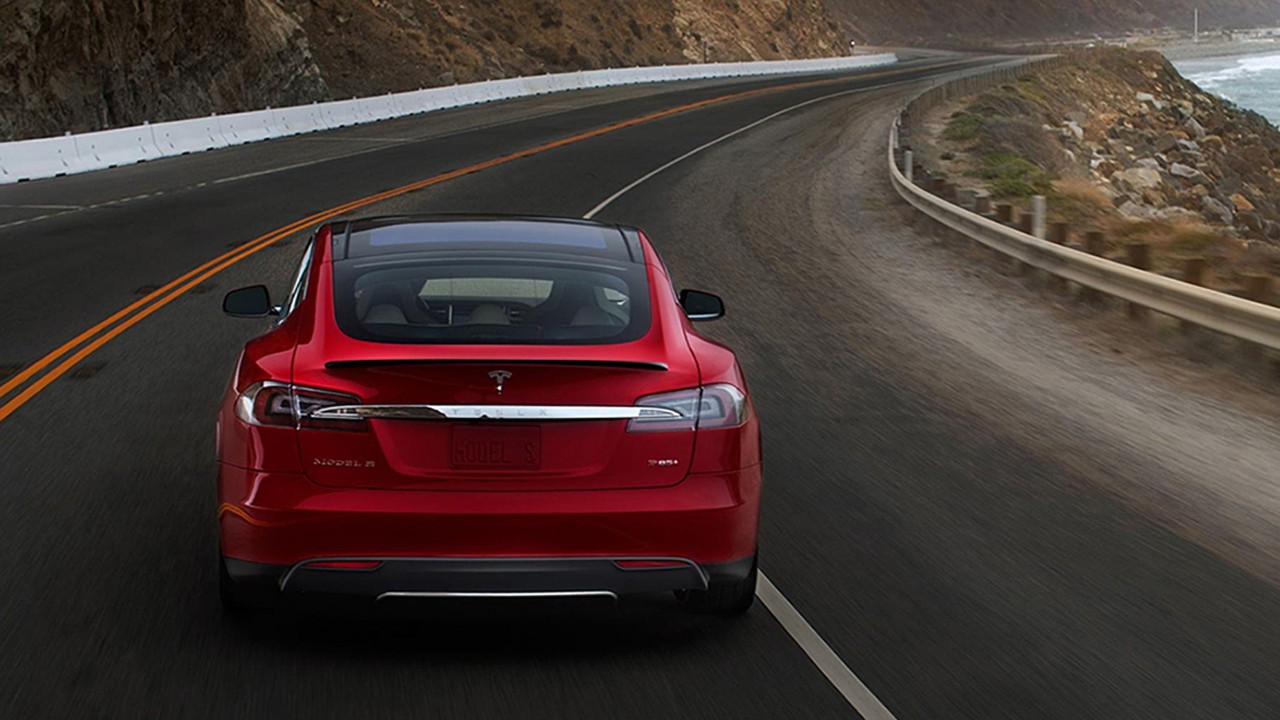 Red Car driving along curvy highway