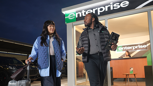 Male enteprise employee walking and talking to a female customer